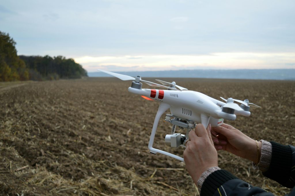 To increase agricultural efficiency, an IoT farming drone hovers over a field, tracking crop health and soil moisture levels.