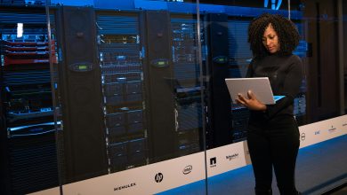 Software Engineer standing beside a Server Rack