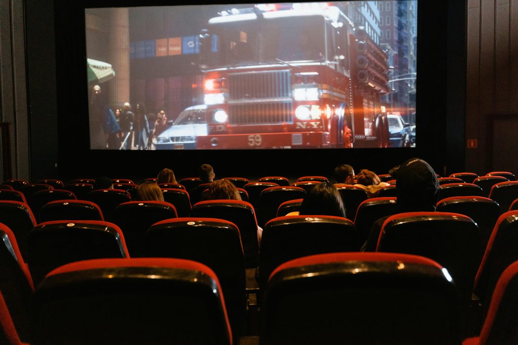 a gathering of individuals watching a movie in a dimly lit theater

